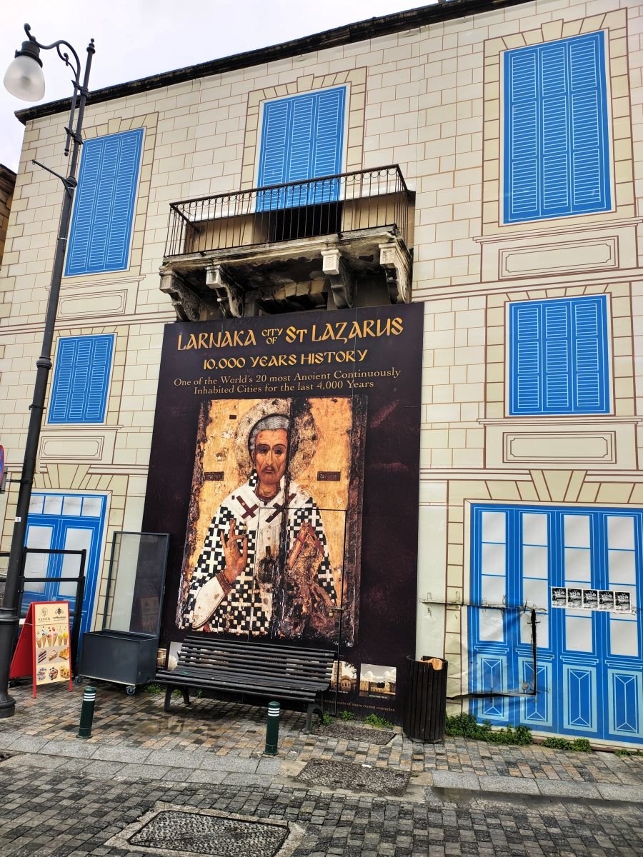Пано „Ларнака – градът на Свети Лазар“ с икона на светеца върху фасада в Ларнака